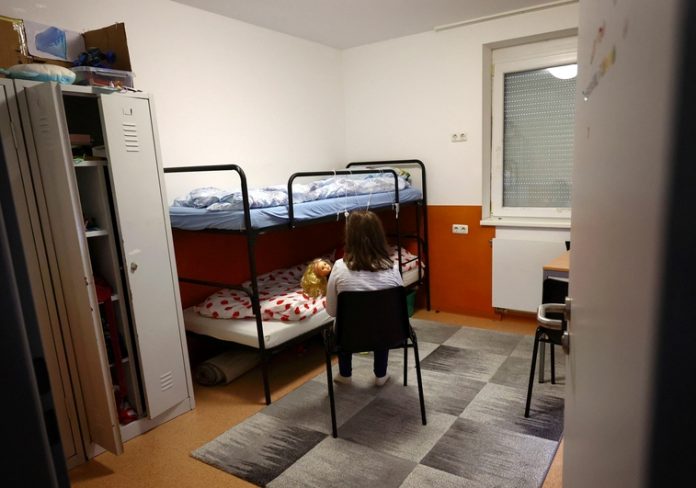 A girls plays with her doll inside a container-built refugee shelter in Hofheim