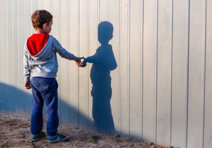 boy and his shadow. Lonely little child playing with his shadow