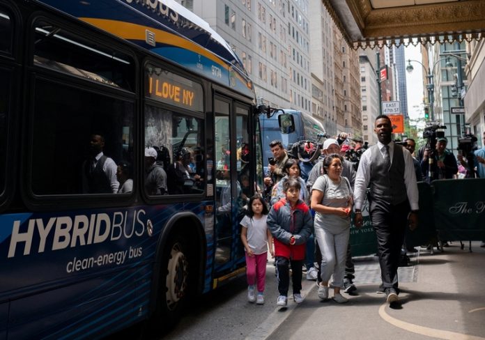 A family of asylum-seekers arrives at the Roosevelt Hotel where migrants are currently being housed, in New York City