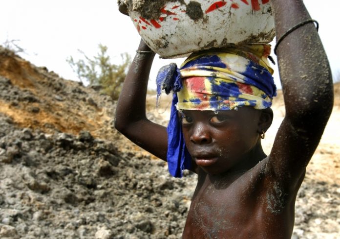Madelaine Dog, 8, carries excavated earth from a salt mine hole on Senegal's coastline