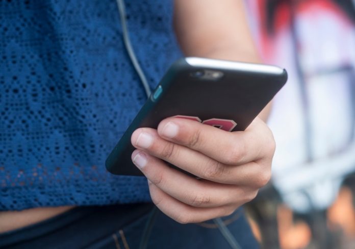 détail main de jeune fille et téléphone portable